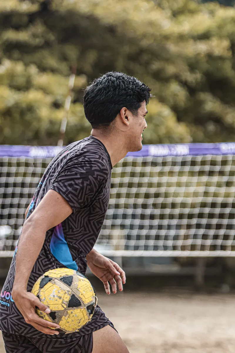 Atleta com a bola na quadra do CT